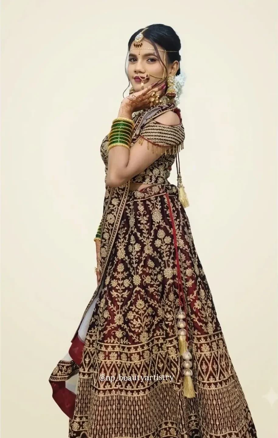 Bride in profile showing the full velvet lehenga, dupatta drape and finished hair